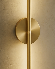 Close-up of the Camber gold linear wall light and round mounting plate