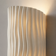 Close-up of the white Corby wall light's flowing ribbed resin surface