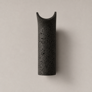 Dorset travertine wall light in the black stone finish on a neutral background