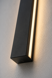 Close-up of the Ealing linear outdoor wall light matte black housing and warm LED strip