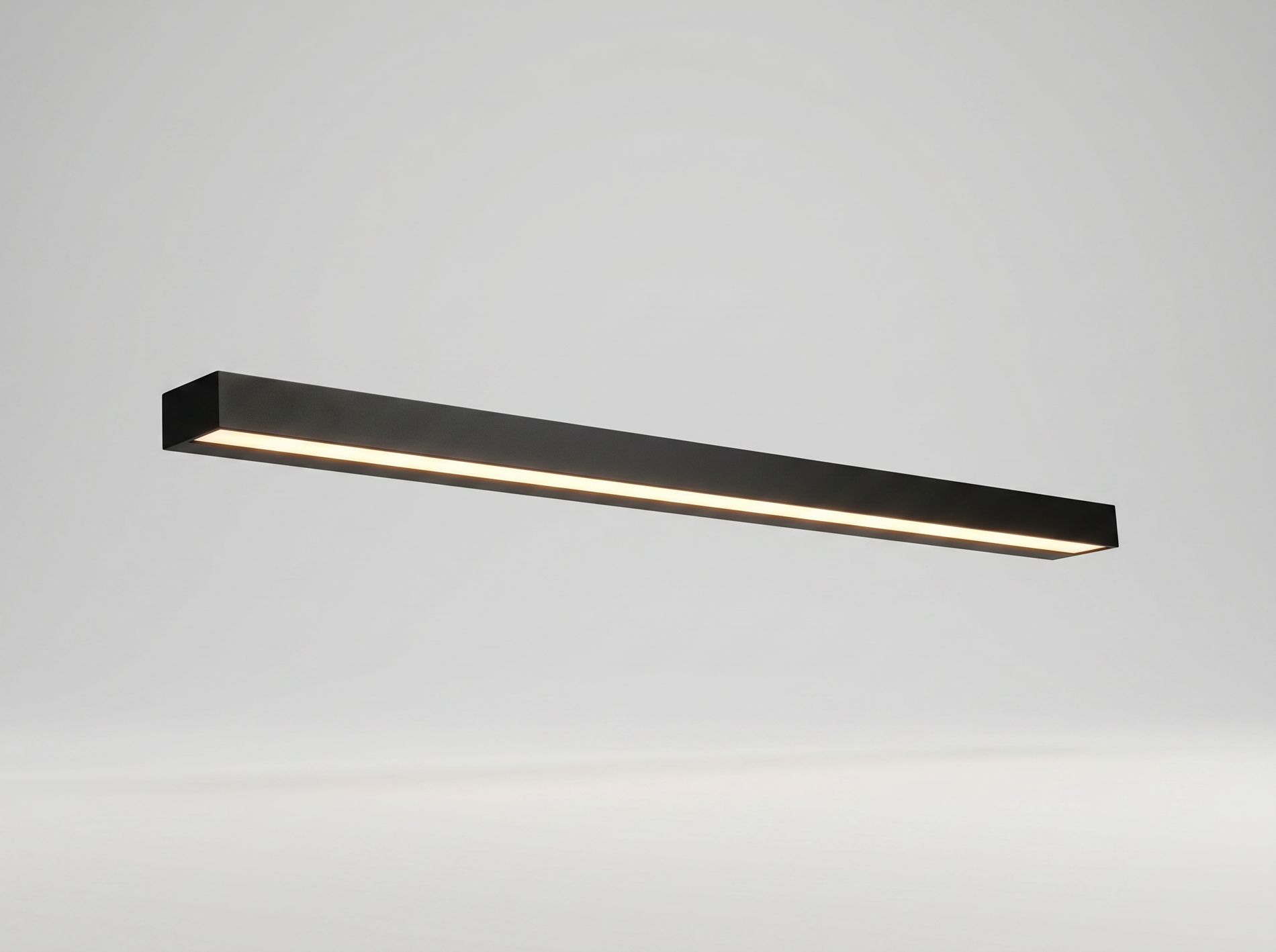 Black linear outdoor wall light glowing on a clean studio background