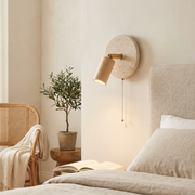 Primrose Light Wood Rotatable Travertine Wall Light - Light Wood finish, installed on bedroom wall