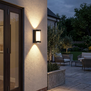Hampstead Tall Up Down Outdoor Wall Light casting light up and down beside a patio door at dusk