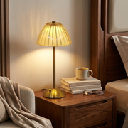Cordless table lamp glowing softly on a bedside table