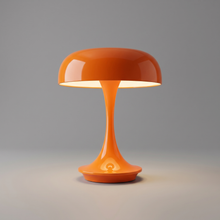 Orange cordless table lamp switched on with a soft warm glow