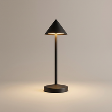 Black cordless table lamp switched on with a soft warm glow