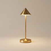 Gold cordless table lamp switched on with a soft warm glow