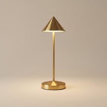Gold cordless table lamp switched on with a soft warm glow