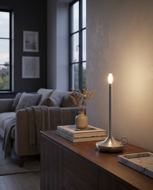 Silver cordless table lamp glowing on a console table in a warm room