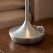 Close-up of the silver aluminium cordless table lamp base and switch detail