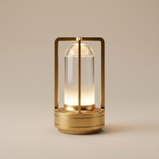 Gold cordless table lamp switched on with a soft warm glow