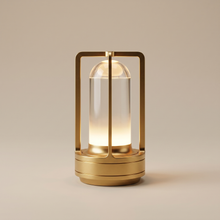 Gold cordless table lamp switched on with a soft warm glow