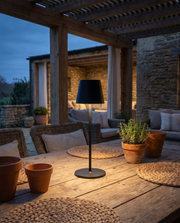 Cordless table lamp glowing on a covered patio table in the evening