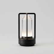 Black cordless table lamp switched on with a soft warm glow