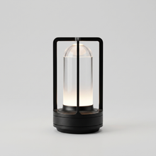 Black cordless table lamp switched on with a soft warm glow