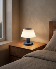 Cordless table lamp glowing on a bedside table in a warm bedroom