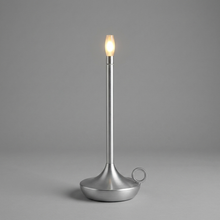 Silver cordless table lamp switched on with a soft warm glow
