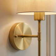 Close-up of brass backplate and fabric shade detail on wall light