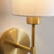Close-up of brass backplate and fabric shade detail on wall light