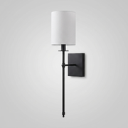 Black candlestick-style wall light with white fabric shade on plain background