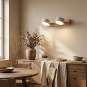 Travertine duo wall light glowing above a dining sideboard