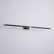 Black and brass linear wall light on plain background