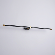 Black and brass linear wall light on plain background