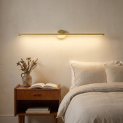 Long linear wall light above a bedside table