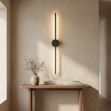 Dark linear wall light above a hallway console table