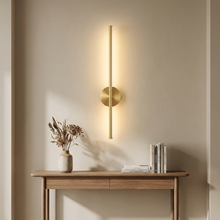 Gold vertical linear wall light above a hallway console table