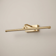 Gold battery wall light on a clean studio background