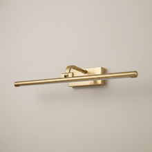 Gold battery wall light on a clean studio background