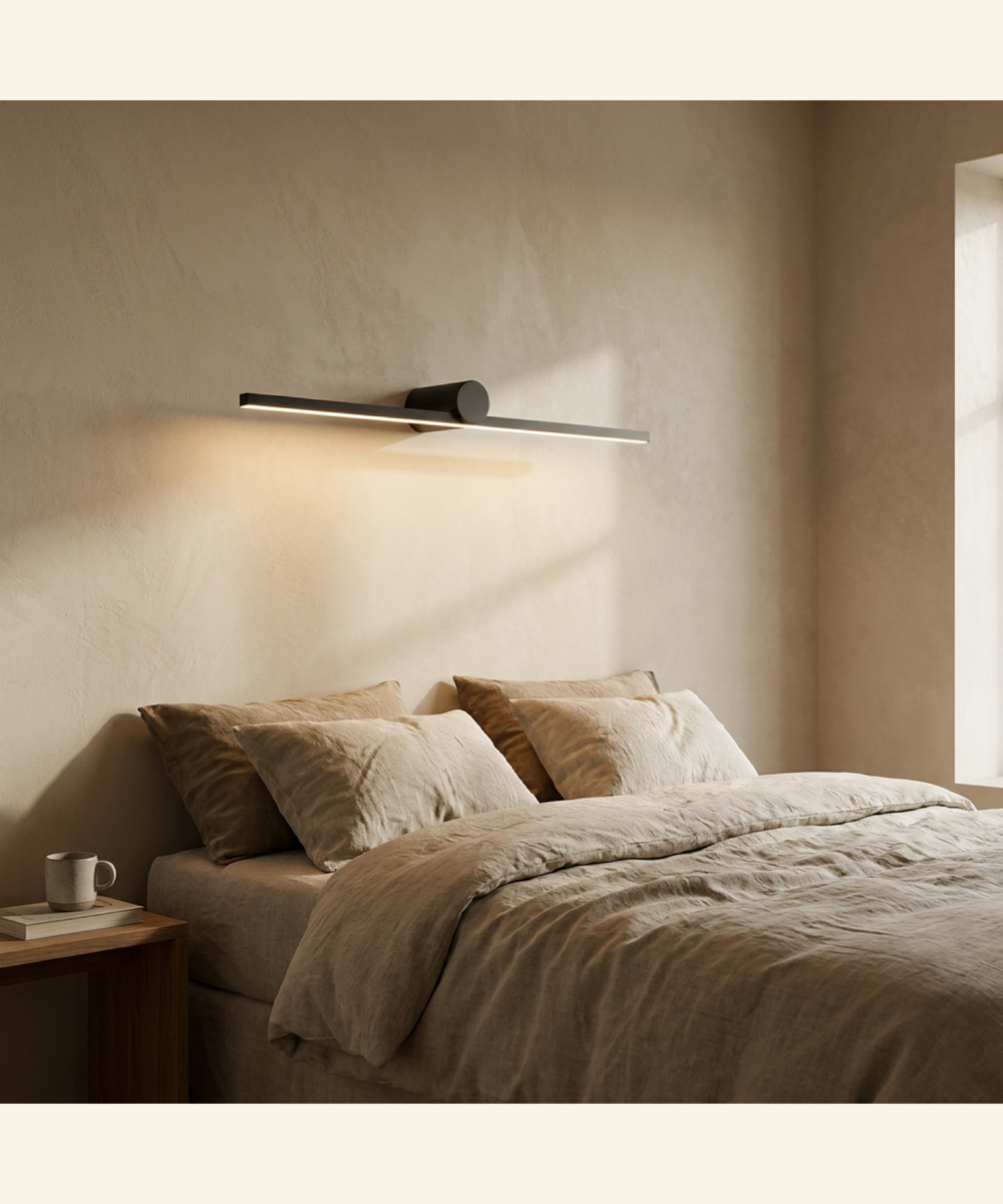 Rechargeable wall light glowing beside a bed in a warm bedroom