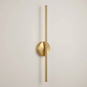 Gold battery wall light on a clean studio background