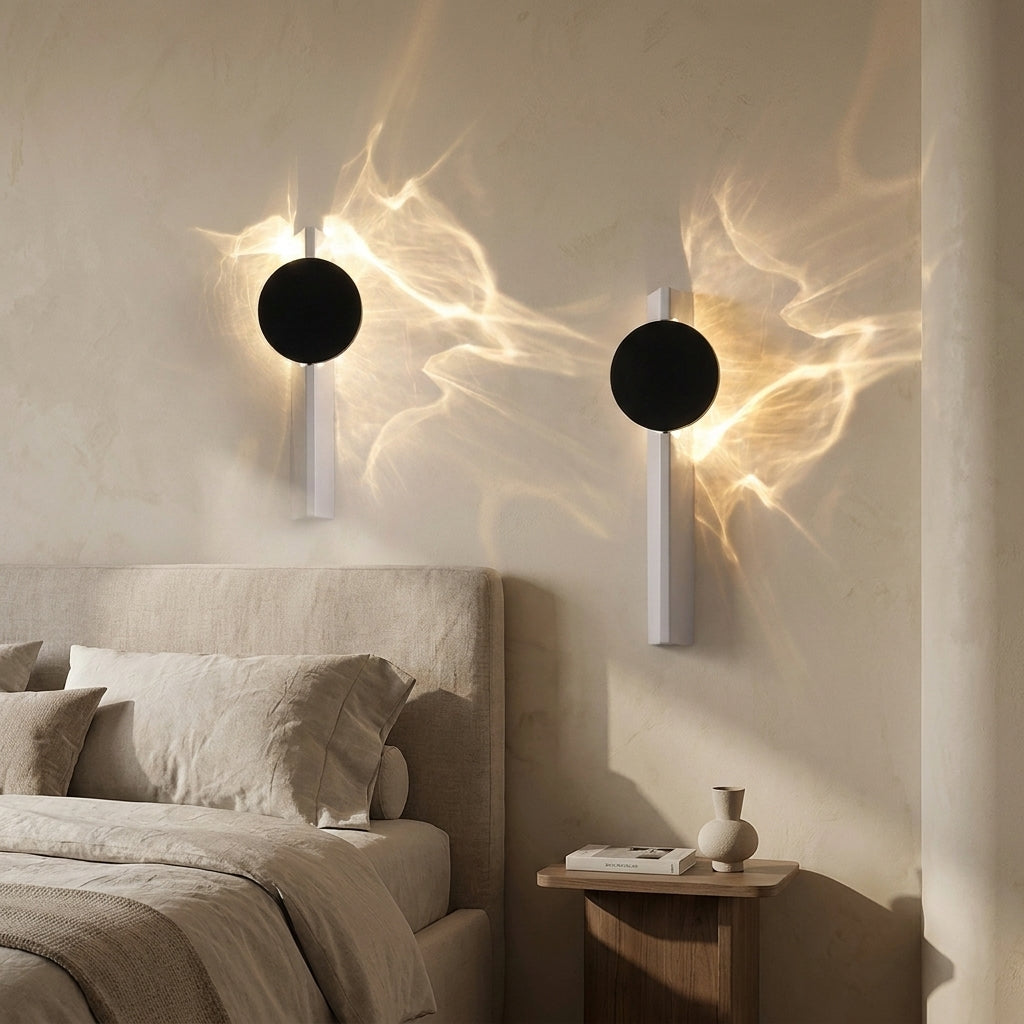Dual-light battery wall light glowing warmly beside a bed