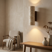 Travertine wall light glowing on a feature wall in a warm living room