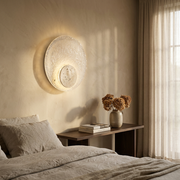 Travertine acrylic wall light glowing on a feature wall in a modern bedroom