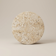 Round travertine wall sconce on a clean studio background