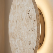 Close-up of natural travertine stone texture on round wall sconce