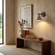 Cone-shaped travertine wall light glowing on a living room feature wall