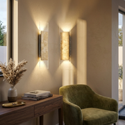 Travertine wall light glowing on a hallway feature wall