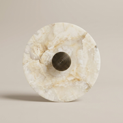Kingston alabaster wall light with round brass centre knob on a clean background