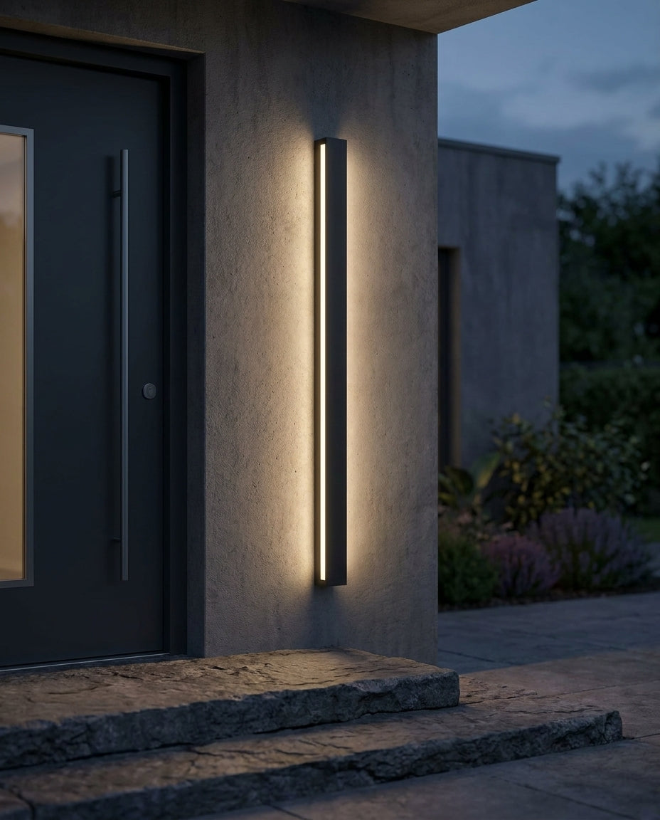 Black linear outdoor wall light beside a front door with warm evening glow