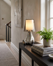 Chrome cordless table lamp with tapered glass shade on a hallway console table
