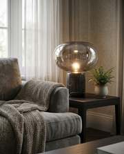 Black marble glass dome table lamp glowing beside a sofa