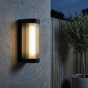 Farringdon Large Rectangular Outdoor Wall Light - Black with ribbed glass diffuser, on a stone wall at dusk