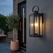 Islington Metal Lantern Outdoor Wall Light - Black, beside a door at dusk