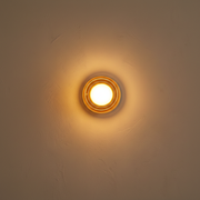 Lumiere Glass Wireless Wall Sconce - amber glass, on a clean studio wall