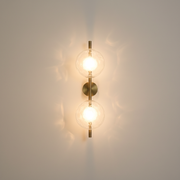Moreton Glass Round Wireless Wall Sconce - Gold, on a clean studio wall