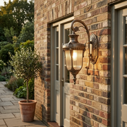 Ely Outdoor Wall Light - Bronze, beside a front door at dusk